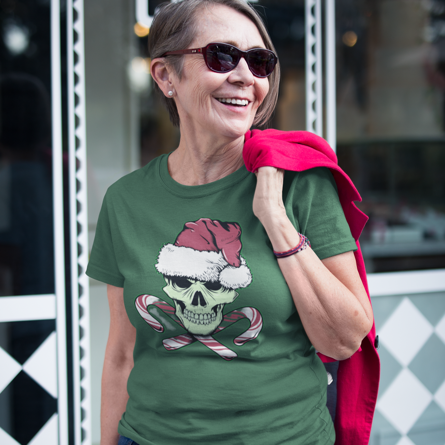 Woman wearing a green t-shirt with a skull design in front of a coffee shop.